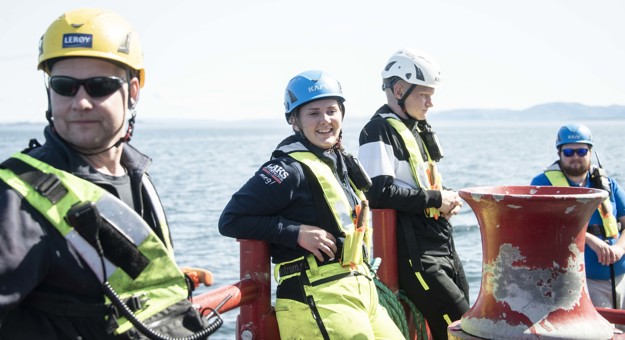 Employees with gear outside working at the fish cages