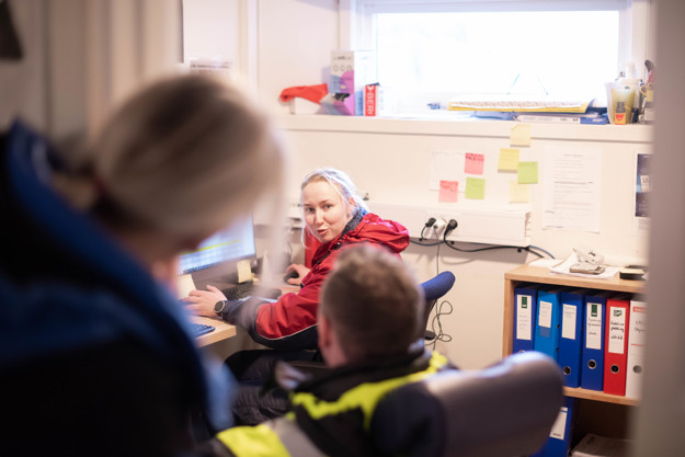 Agnete talking to two people you see the back off. In Agnetes office